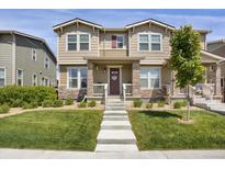 Charming two-story home featuring stone accents, a welcoming front porch, and a well-manicured lawn at 4391 S Nepal St, Centennial, CO 80015