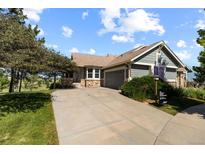 Charming single-story home with a well-manicured front lawn and a concrete driveway leading to an attached two-car garage at 7713 S Zante Ct, Aurora, CO 80016
