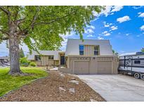 Inviting exterior view of home with a well-manicured lawn, mature tree, and a two-car garage at 3378 Mowry Pl, Westminster, CO 80031