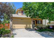 Charming two-story home boasts a well-manicured lawn, mature trees, and welcoming curb appeal at 5241 E 128Th Way, Thornton, CO 80241
