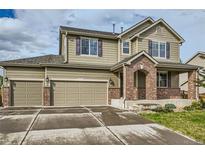 Two-story house with brick and siding, attached two-car garage, and landscaping at 5353 Royal Pine St, Brighton, CO 80601