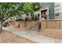 Charming townhomes feature well-kept landscaping and inviting front entrances with concrete steps and black metal railings at 9503 Longs Peak Dr, Commerce City, CO 80640