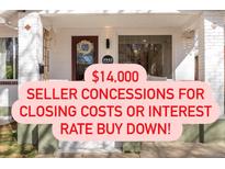 Charming front porch of a home with white brick, decorative door wreath, and hanging pendant light at 3942 Alcott St, Denver, CO 80211