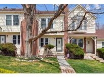Charming townhome with manicured lawn, mature trees, and brick accents on the exterior at 7665 S Steele St, Centennial, CO 80122