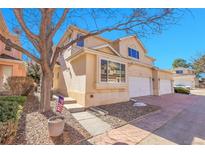 Charming exterior featuring stucco siding, attached garage, and manicured front yard, complemented by a mature tree at 12420 E Iliff Pl, Aurora, CO 80014