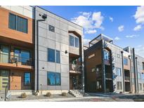 Modern townhome exterior showcasing mixed material facade, balconies, and landscaped entryways under a bright sky at 3017 W 53Rd Ave, Denver, CO 80221