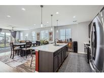 Modern kitchen featuring stainless steel appliances, a large island, and open dining area with lots of natural light at 9679 Waco St, Commerce City, CO 80022