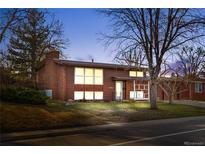 Exterior of home at dusk showcasing mature trees, a well-manicured lawn, and charming architectural details at 8061 S Kendall Blvd, Littleton, CO 80128