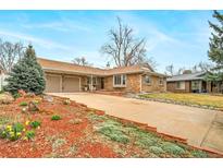Charming brick home featuring an attached two-car garage and well-maintained landscaping at 2424 S Jasmine St, Denver, CO 80222