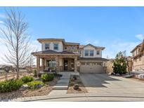 Beautiful two-story home with stone and stucco exterior, landscaped front yard and three car garage at 1240 Starglow Pl, Highlands Ranch, CO 80126