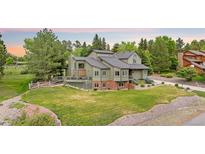 Charming home featuring an elevated deck, mature trees, and manicured lawn, set on a beautiful lot at 7398 E Windlawn Way, Parker, CO 80134