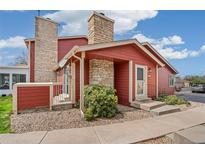 Charming red home with stone accents, landscaped front yard, and inviting entryway at 8424 Everett Way # A, Arvada, CO 80005