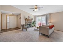 Inviting living room featuring a cozy fireplace, sliding glass doors, and neutral decor at 8424 Everett Way # A, Arvada, CO 80005