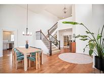 Bright entryway boasts hardwood floors, staircase, and modern lighting fixtures at 10222 Gemstone Ct, Parker, CO 80134