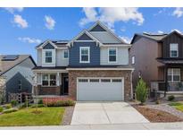 Charming two-story home featuring a brick front, white garage door, and a landscaped yard at 9807 Rosalee Peak St, Littleton, CO 80125