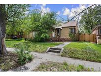 Charming brick home featuring a well-maintained front yard and mature trees offering shade at 1439 Dexter St, Denver, CO 80220
