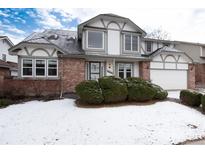Charming two-story home featuring a brick facade, well-manicured landscaping, and attached two-car garage at 8182 Sweet Water Rd, Lone Tree, CO 80124