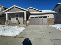 Gray exterior boasts a two-car garage and snowy front yard at 4799 Astor Pl, Brighton, CO 80601