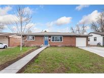 Charming single-story brick home featuring a blue front door, well-maintained lawn, and attached garage at 1958 S Raleigh St, Denver, CO 80219