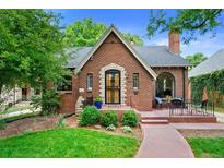 Charming brick home with a cozy front porch and lush landscaping creates inviting curb appeal at 1040 S Elizabeth St, Denver, CO 80209
