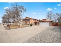 Charming two-story home with attached garage, long driveway, and landscaped front yard at 838 S 10Th Ave, Brighton, CO 80601