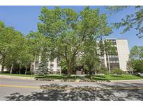 Inviting condominium exterior with mature trees, lush landscaping, and well-maintained facade at 3465 S Poplar St # 305, Denver, CO 80224