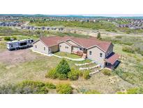 Expansive exterior of home featuring lush green landscape and neutral siding with a recreational vehicle parked on the side at 4959 Rocky View Pt, Castle Rock, CO 80108