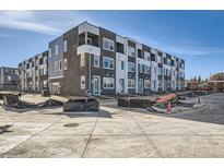 Modern townhome featuring stylish brick and siding, set against a clear blue sky at 370 N. Geneva St, Aurora, CO 80010
