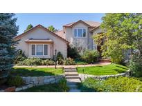 Charming home featuring manicured lawn, stone accents and mature trees at 1977 Champions Cir, Castle Rock, CO 80104