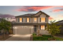Charming two-story home featuring a well-manicured lawn, solar panels, and inviting curb appeal at sunset at 6387 Agave Ave, Castle Rock, CO 80108