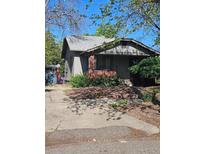 Charming single-story home featuring a brick porch and a well-maintained front yard with mature trees at 2117 S Lafayette St, Denver, CO 80210
