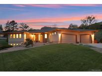 Stunning home with a three-car garage, beautiful landscaping, and a lush green lawn at 4305 Easley Rd, Golden, CO 80403