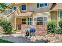 Inviting townhome with a charming brick facade and well-maintained landscaping at 2181 S Troy Way # 103, Aurora, CO 80014
