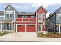 Beautiful two-story red home with a two-car garage and second story deck at 285 Clementina St, Louisville, CO 80027