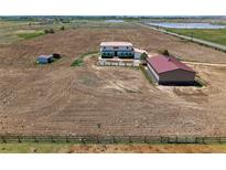Expansive aerial view of home, farm, and outbuildings on acreage with lake views in the distance at 3160 Bella Rosa Pkwy, Longmont, CO 80504