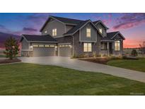 Stunning two-story home featuring a three-car garage, stone accents, and beautifully landscaped front yard at 8750 Red Primrose St, Franktown, CO 80116