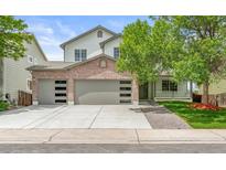 Charming two-story home featuring a brick facade, three-car garage, and a well-manicured front lawn at 11383 Oakland Dr, Commerce City, CO 80640
