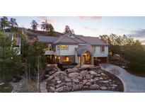 Stunning two-story home with stone landscaping and a charming covered front porch at 4788 Silver Pine Dr, Castle Rock, CO 80108