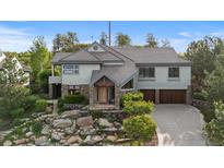 Beautiful two-story home featuring a stone accents, a two-car garage and professionally landscaped front yard at 4788 Silver Pine Dr, Castle Rock, CO 80108