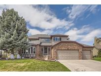 Charming two-story home with brick accents and well-manicured lawn at 6340 Ashburn Ln, Highlands Ranch, CO 80130
