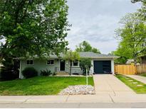 Charming one-story home with a well-maintained front yard, a new garage door, and attractive landscaping at 8307 E Lehigh Dr, Denver, CO 80237