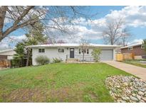 Charming single-story home featuring a well-maintained lawn and a driveway leading to an attached garage at 8307 E Lehigh Dr, Denver, CO 80237