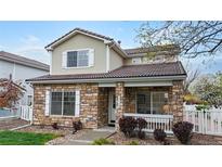 Charming two-story home featuring a stone facade, covered porch, and well-maintained landscaping at 11738 Zenobia Loop, Westminster, CO 80031
