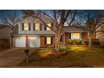 Charming brick two-story home with a well-manicured lawn, mature tree, and attached two-car garage at 17093 E Pacific Pl, Aurora, CO 80013