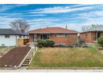 Charming brick home with a well-maintained lawn and landscaped front yard, creating great curb appeal at 3670 Ivanhoe St, Denver, CO 80207