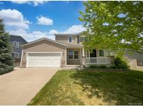 Charming two-story home with a well-manicured lawn, attached garage, and inviting front porch at 12550 Eastlake Dr, Thornton, CO 80241