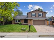 Charming two-story home with well-manicured lawn and attached two-car garage at 8268 W Caley Pl, Littleton, CO 80123