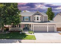 Charming two-story home with a three-car garage, well-manicured lawn, and welcoming front porch at 1774 Spring Water Pl, Highlands Ranch, CO 80129