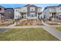 Charming townhouse with gray siding, stone accents, and well-maintained landscaping at 8211 Monte Vista Cir, Littleton, CO 80125