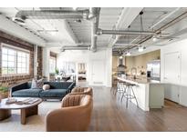 Bright, modern living room with exposed ductwork, brick accent wall and open concept kitchen at 1435 Wazee St # 305, Denver, CO 80202